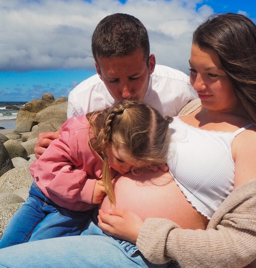 Famille en attente d’un bébé, le partenaire et l’aînée embrassent le ventre de la maman enceinte dans un moment de connexion avant la naissance